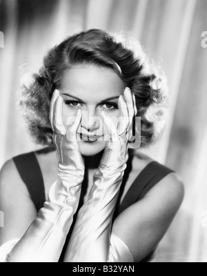 Woman framing her face with satin gloved hands Stock Photo
