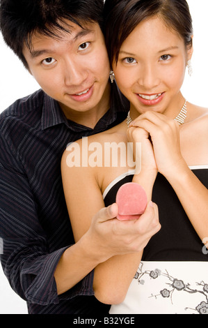 A young woman looks delighted by her man's gift (both looking at camera) Stock Photo