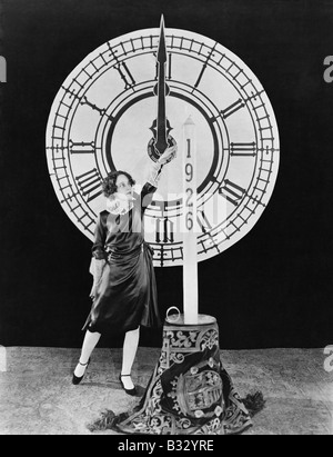 Woman with candle and clock on New Years Eve Stock Photo