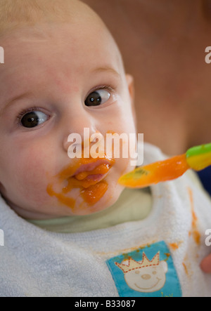 baby eats carrot mash Stock Photo