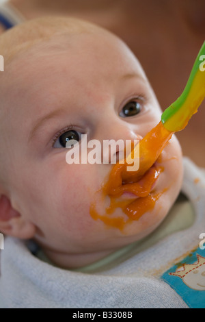 baby eats carrot mash Stock Photo