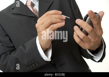 a businessman in grey suit uses an electronic organiser Stock Photo
