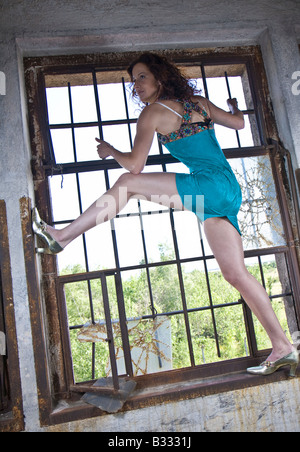 young woman climbing on window Stock Photo - Alamy