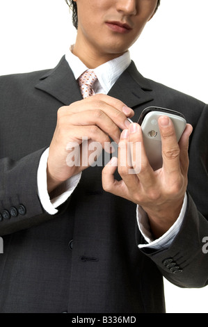 An asian businessman writes notes on his pocket PC Stock Photo