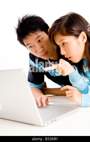 A young asian woman points at the laptop screen Stock Photo