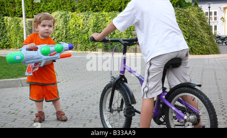 young boy with big water pistol Stock Photo