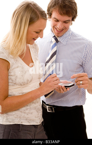 Two attractive young executives looking at a handheld electronic device Stock Photo