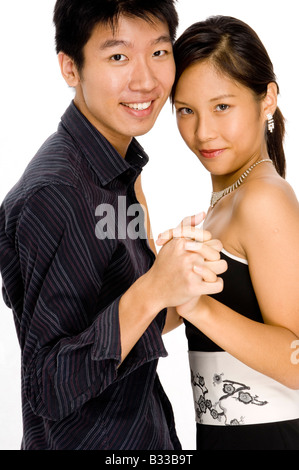 A young asian couple stand closely and hold hands Stock Photo