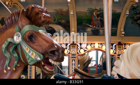 Close up of biting Merry Go Round horse with colourful decoration mirrors and painting in back ground Stock Photo