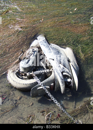 one old scooter dumped in river Stock Photo