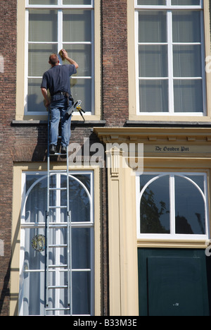window cleaner at work in centre of Middelburg Zeeland Netherlands Stock Photo