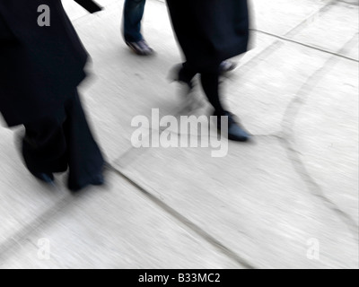 A view of women shoes while walking down a paved sidewalk Stock Photo