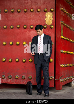 A Chinese businessman using his mobile phone for his benefit or business purposes. Stock Photo