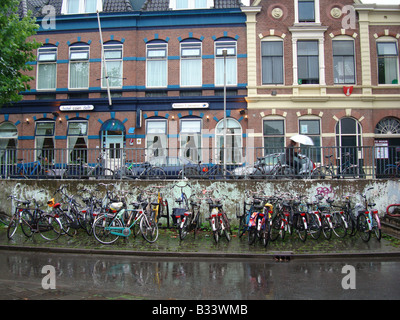 student bicycles parked in front of student homes Delft Zuid Holland Netherlands Stock Photo