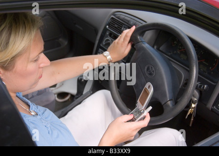 Woman texting whilst driving Stock Photo