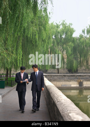 Chinese Businessmen discussing  while looking over a document, Stock Photo