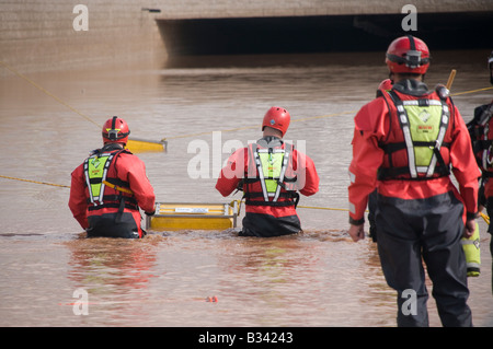 Emergency rescue firemen position submersible pump in floodwater Stock Photo