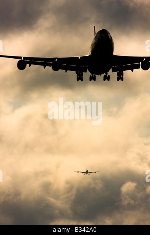 Wake turbulence forms behind aircrafts as they passes through the clouds when descending for landing. London Heathrow Airport UK Stock Photo