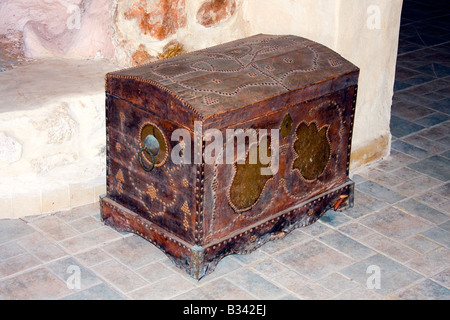 Very old wooden chest by the wall. Stock Photo