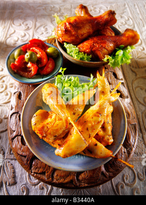 party food - From Front - Marinated chicken skewers, Marinaded chicken drum sticks and sun blushed tomatoes. Stock Photo