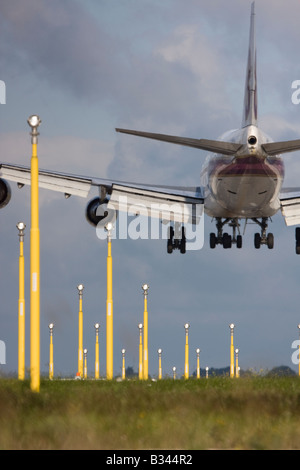 Commercial aeroplane on short final approach to London Heathrow Airport with landing lights in the foreground. Stock Photo