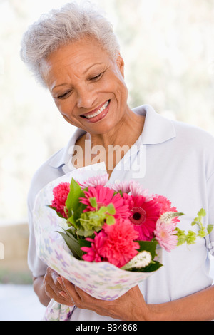 Woman holding flowers and smiling Stock Photo