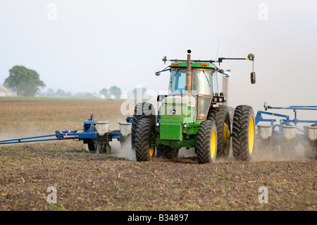 John Deere tractor planting corn or soybeans in an American farm field Stock Photo