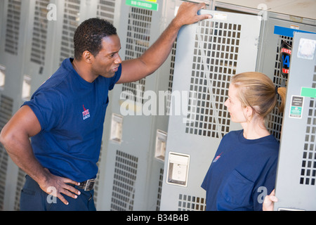 Two firefighters in locker room talking (depth of field) Stock Photo