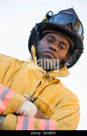 Fireman standing outdoors wearing helmet Stock Photo