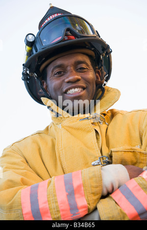 Fireman standing outdoors wearing helmet Stock Photo