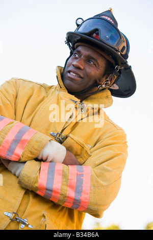 Fireman standing outdoors wearing helmet Stock Photo