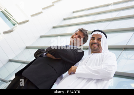 Two businessmen standing outdoors by building (high key/selective focus) Stock Photo