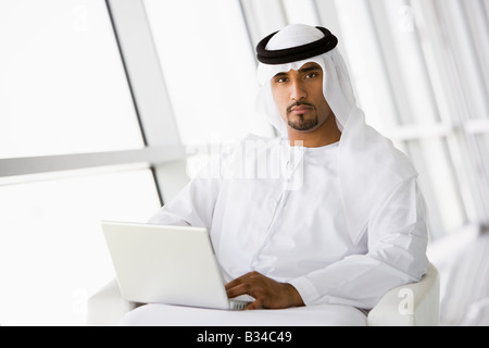 Man indoors with laptop (high key/selective focus) Stock Photo