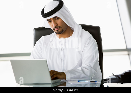 Businessman in office with laptop working (high key/selective focus) Stock Photo