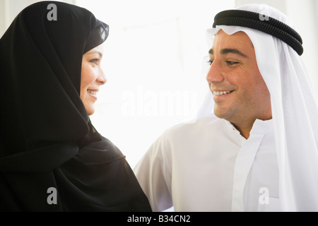 Couple indoors facing each other smiling (high key) Stock Photo