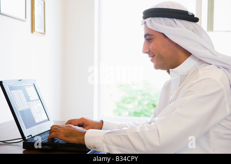 Man in office with laptop smiling (high key/selective focus) Stock Photo