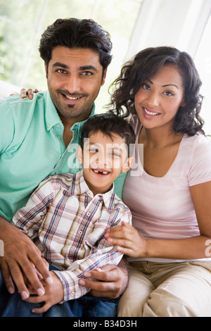 Family in living room sitting on sofa smiling (high key) Stock Photo