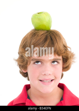 Young boy with apple on his head smiling Stock Photo