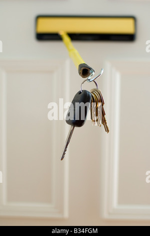 Car and house keys being stolen through letterbox by using a stick with a hook on the end Stock Photo