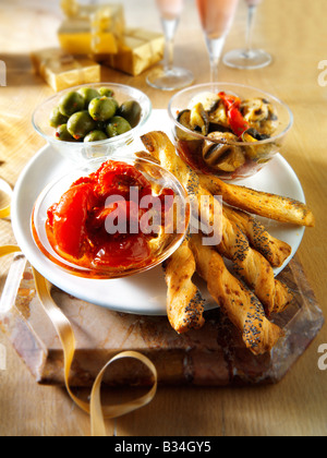 Party Food anti pasta - sun blushed tomatoes, mushroom and roast vegetables and olives with bread sticks. Stock Photo