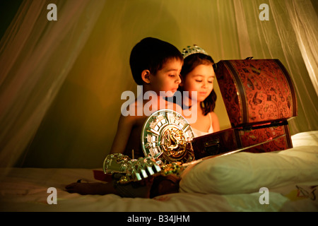 The magical treasure chest Five year old girl and six year old boy at play Brother and sister mixed race Stock Photo