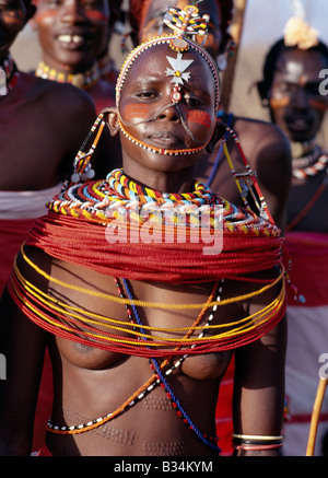 Kenya, Samburu district, Kirimun. A pretty Samburu girl dances with warriors of her tribe.Girls arch their backs and by thrustin Stock Photo