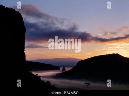 Kenya, Naivasha, Hell's Gate National Park. Early morning ground mist surrounds Fischer's Tower, an ancient volcanic plug, in a Stock Photo