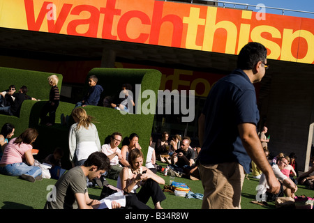 People sit on large fake grass chairs in London, UK Stock Photo