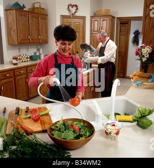 Middle age couple preparing dinner in their kitchen Stock Photo