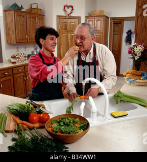 Middle age couple preparing dinner in their kitchen Stock Photo