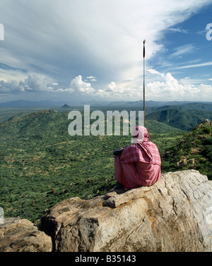 Kenya, Maralal, Kirimun. A Samburu man looks out over a vast tract of unspoilt country as storm clouds gather in the far distant. Stock Photo