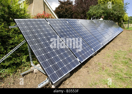 Array of 12 solar PV hybrid 210w panels on galvanised A frame in field Cotswolds UK Stock Photo