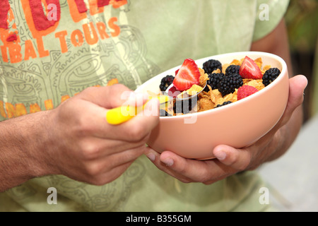 Young Man Eating Cornflakes with Berries Model Released Stock Photo