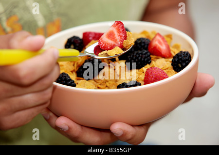 Young Man Eating Cornflakes with Berries Model Released Stock Photo